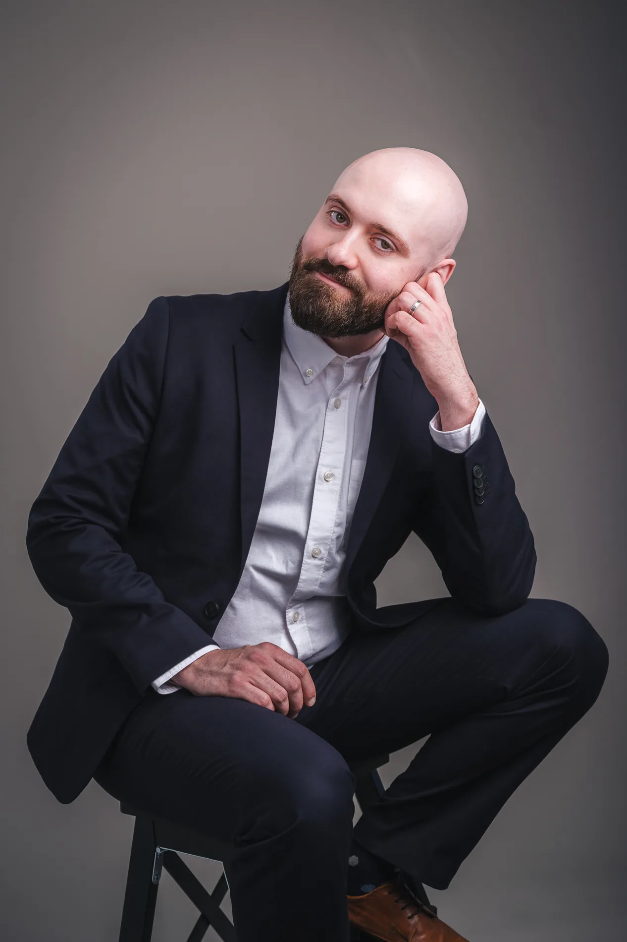Tomi Kouvalainen istumassa tummassa puvussa studiossa